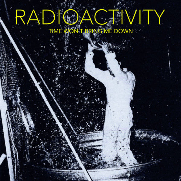 A man in white pouring something over his head in a large bucket
