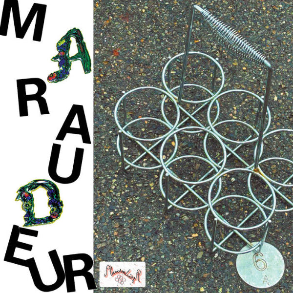 Metallic decorative object on a textured surface with 'Mau德' branding.