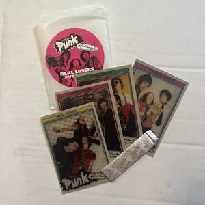 Open pack of REAL LOSERS trading cards with four cards and a stick of gum