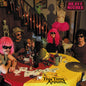 THe band gathered around a table filled with fruit, alcohol, playing cards, money and other items.