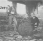 Three people posing with a barrel in a dilapidated building, with 'The 2x4's' text.